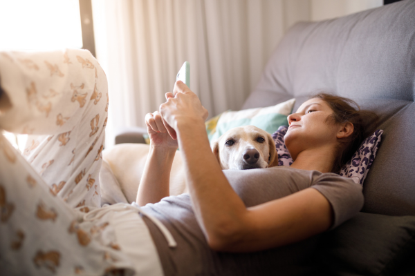 Woman looking at service dog social media accounts with her dog
